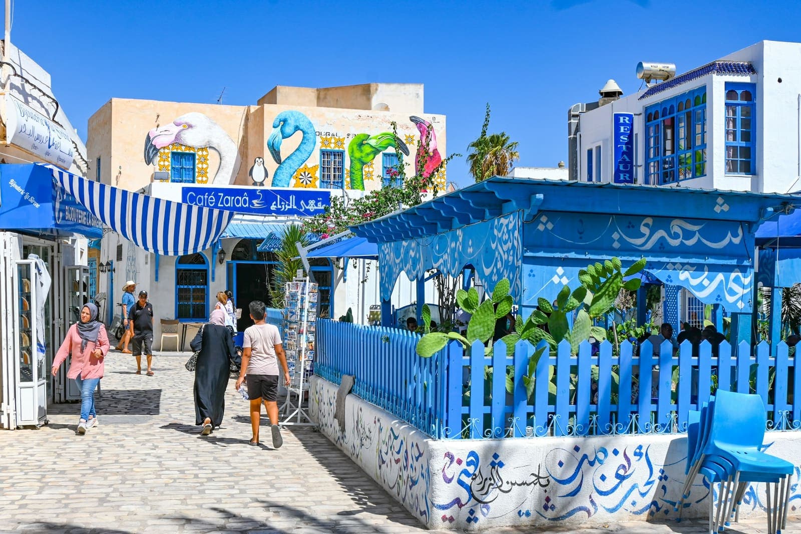 Ruelle blanche et porte bleue d'Erriadh (Djerbahood), patrimoine djerbien